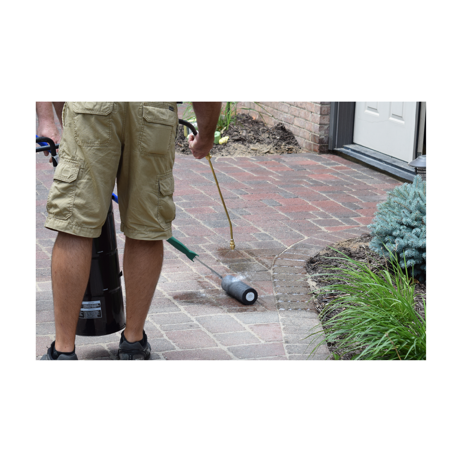 Applying hardscape sealer onto paver patio with slit foam roller
